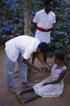 Medical student examines kuru patient at Okapa, 1968. Photo AJR.